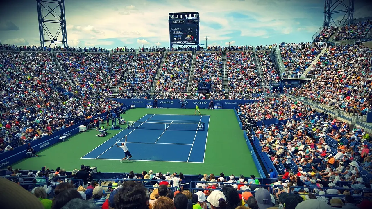 Tenniskamp på stadionbane med stort publikum